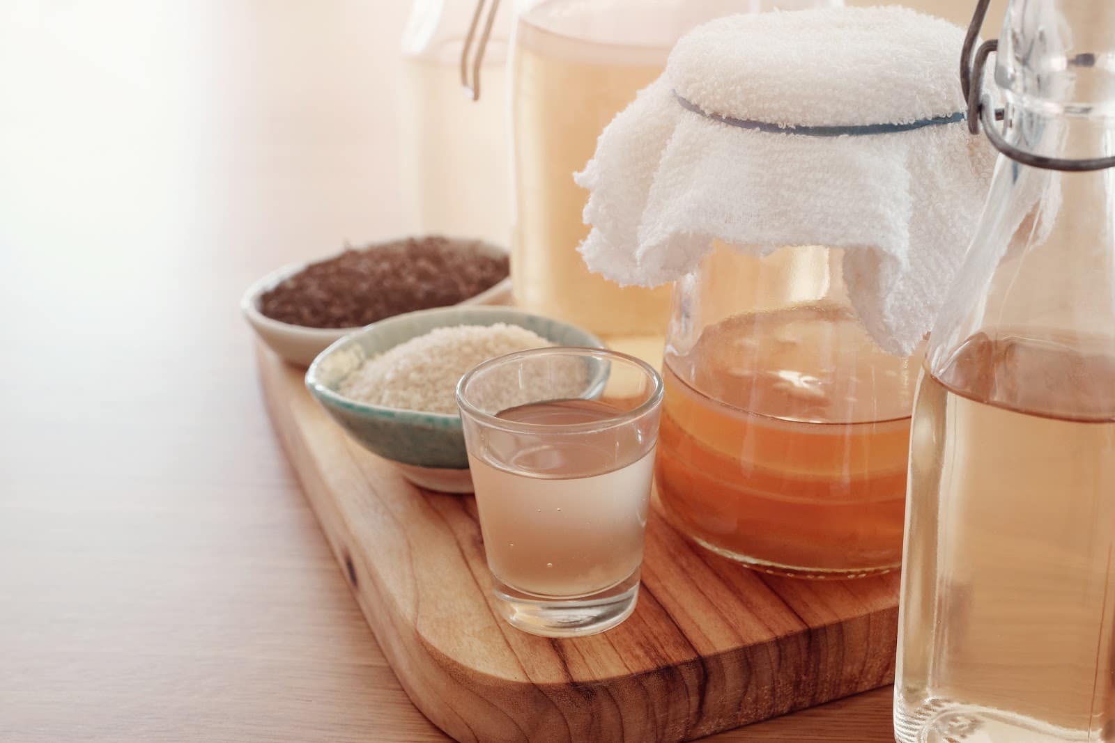 kombucha-and-ingredients-in-glass-and-covered-containers