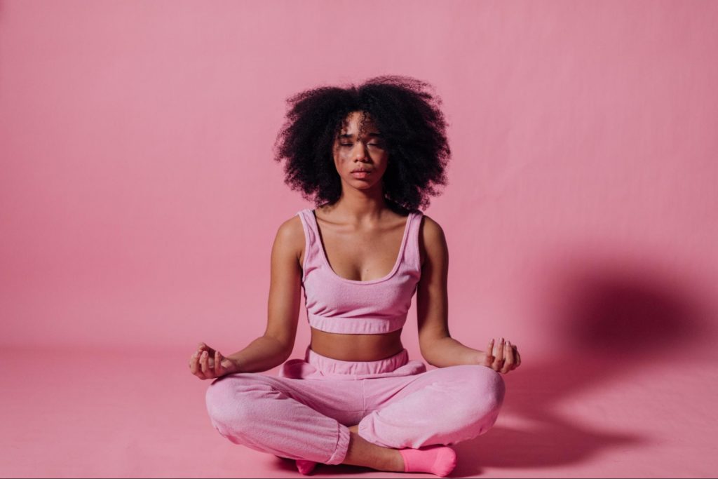 black woman going yoga against pink background