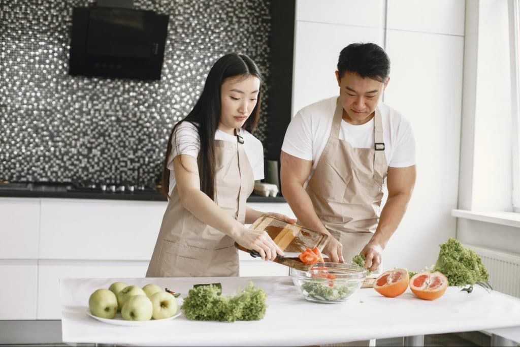 couple making salad on counter