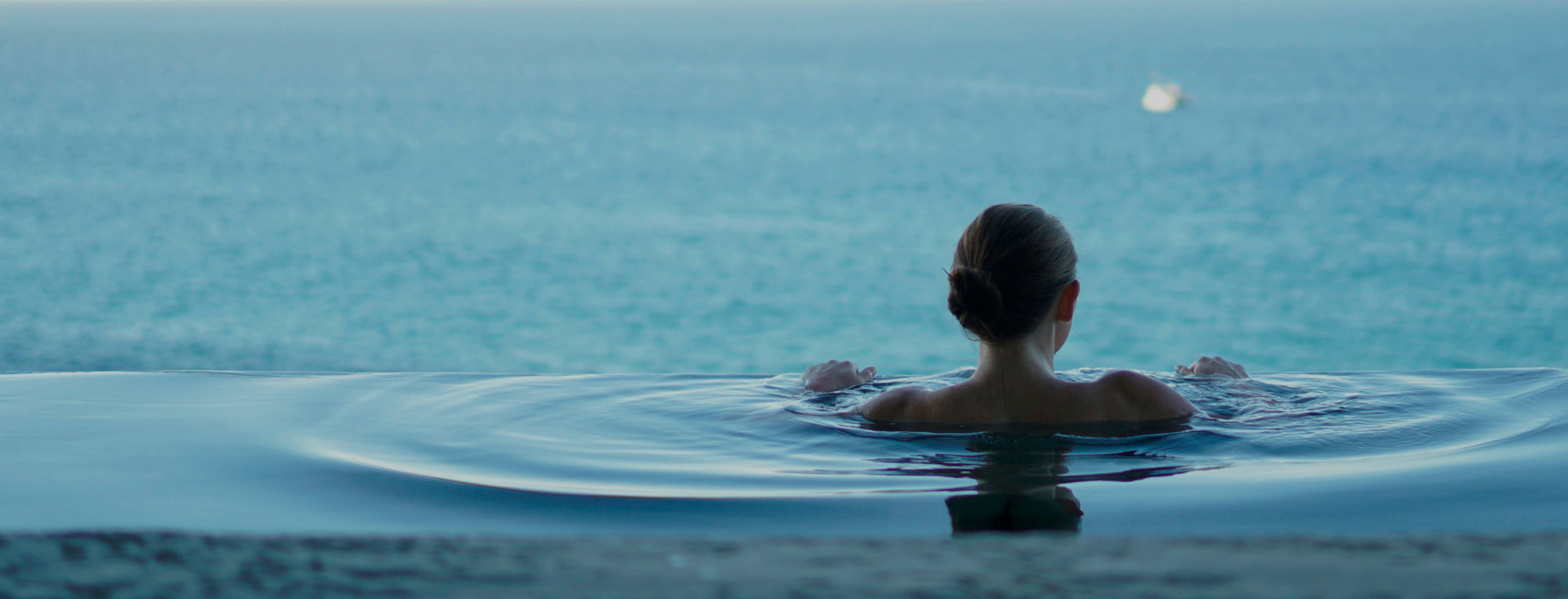 The image shows a woman meditating by a tranquil lake with mountains in the background, symbolizing detox and the need for gut and liver support due to toxin exposure and lifestyle factors