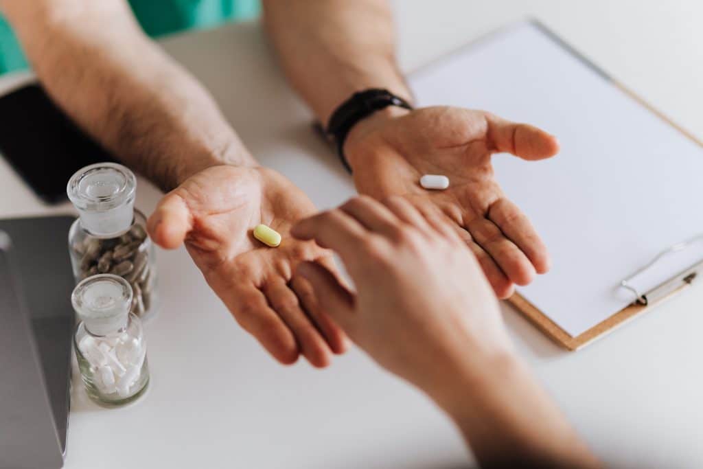 doctor-holding-two-pills-out-in-palm-of-hands