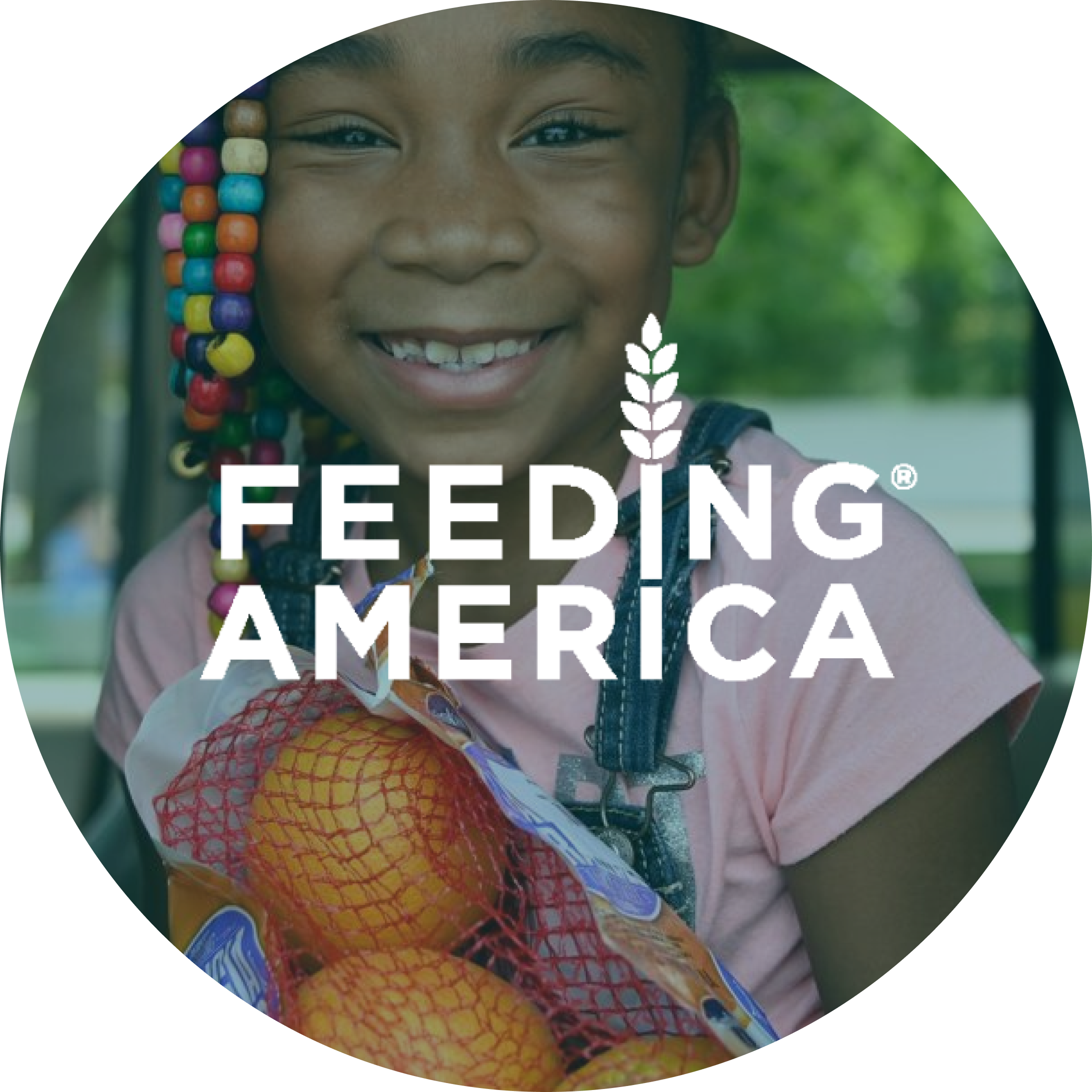 Smiling child holding a bag of oranges with the Feeding America logo overlay