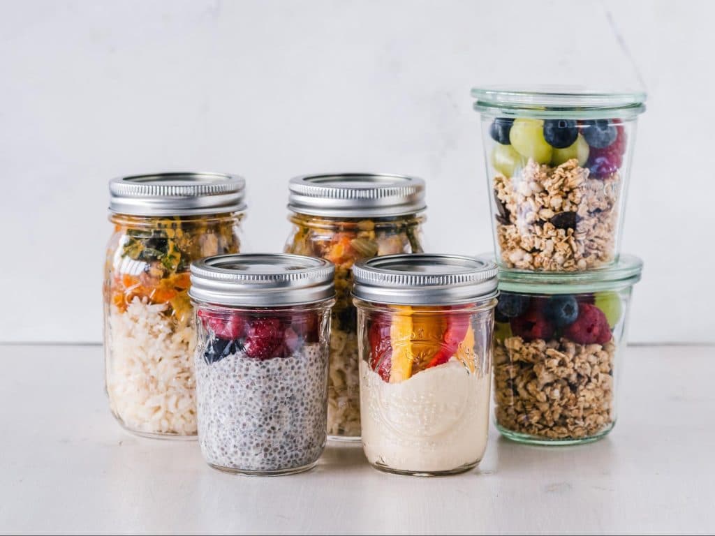 Prebiotic foods including berries and fiber and probiotic foods like yogurt in meal prep jars