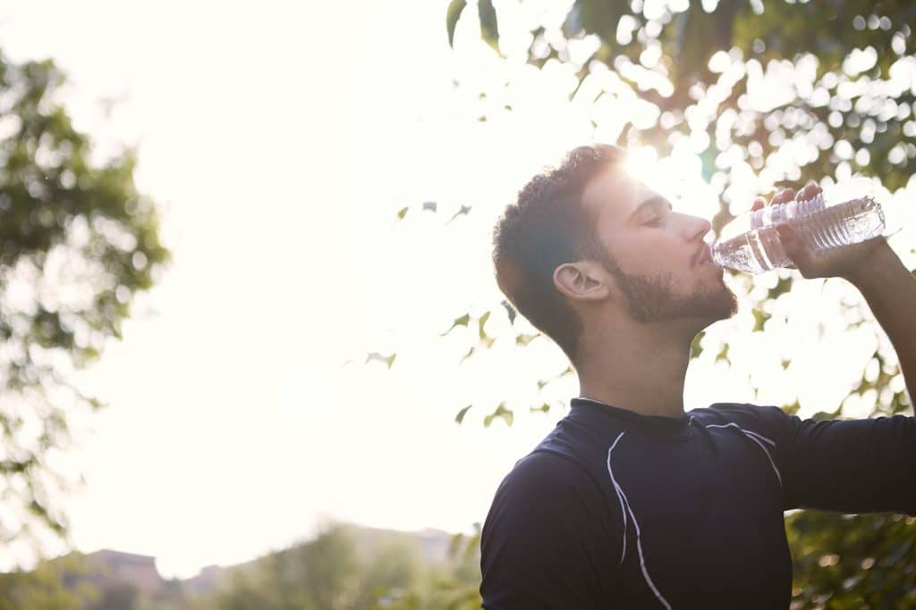 man-in-black-crew-neck-shirt-drinking-water