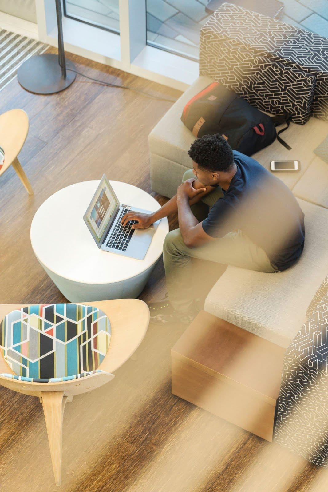 man-using-gray-laptop-while-sitting-on-beige-sofa