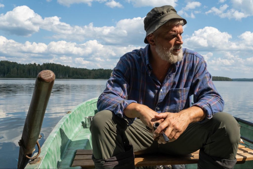 man with pipe sitting on boat