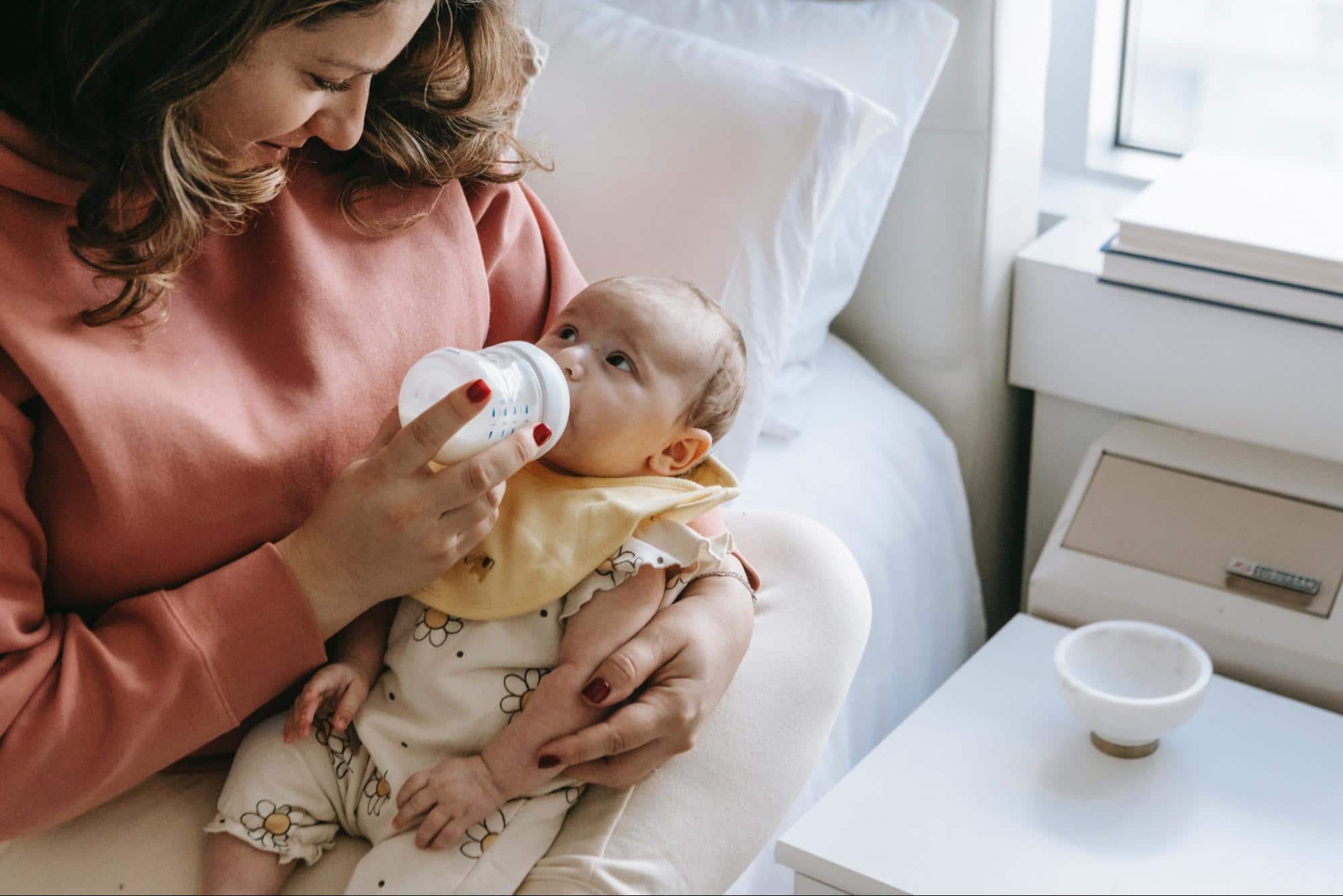 Mother feeding newborn baby from bottle