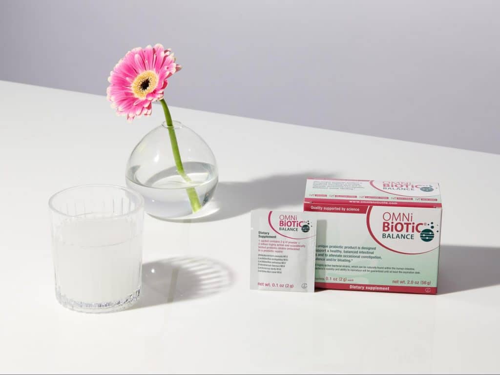 omni biotic balance probiotic supplement with box sachet and glass of water