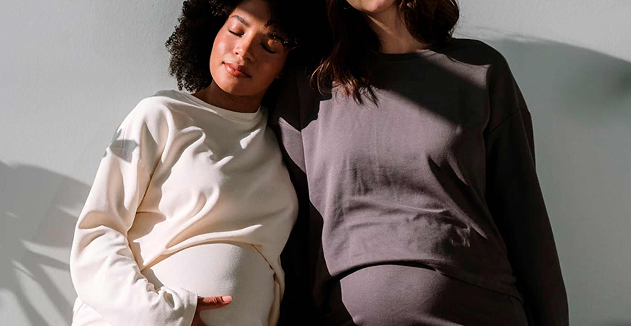 The image shows a pregnant woman standing in a serene meadow, gently cradling her belly, symbolizing prenatal and baby support for a healthy gut microbiome and immune system during pregnancy