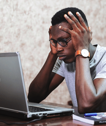 stressed-man-holding-head-in-both-hands-staring-at computer-screen