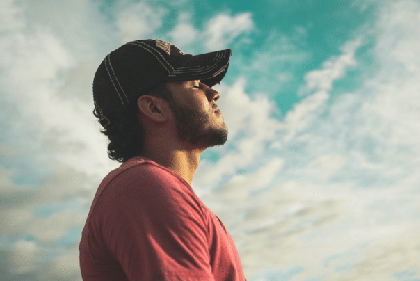 relaxed-man-with-cloudy-sky-in-background