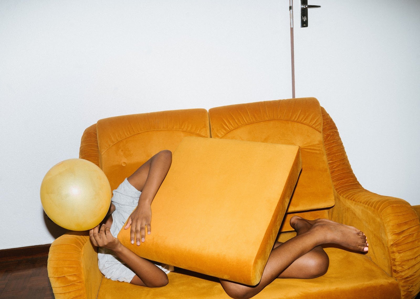 person-lying-on-brown-sofa-chair-with-balloon-covering-face