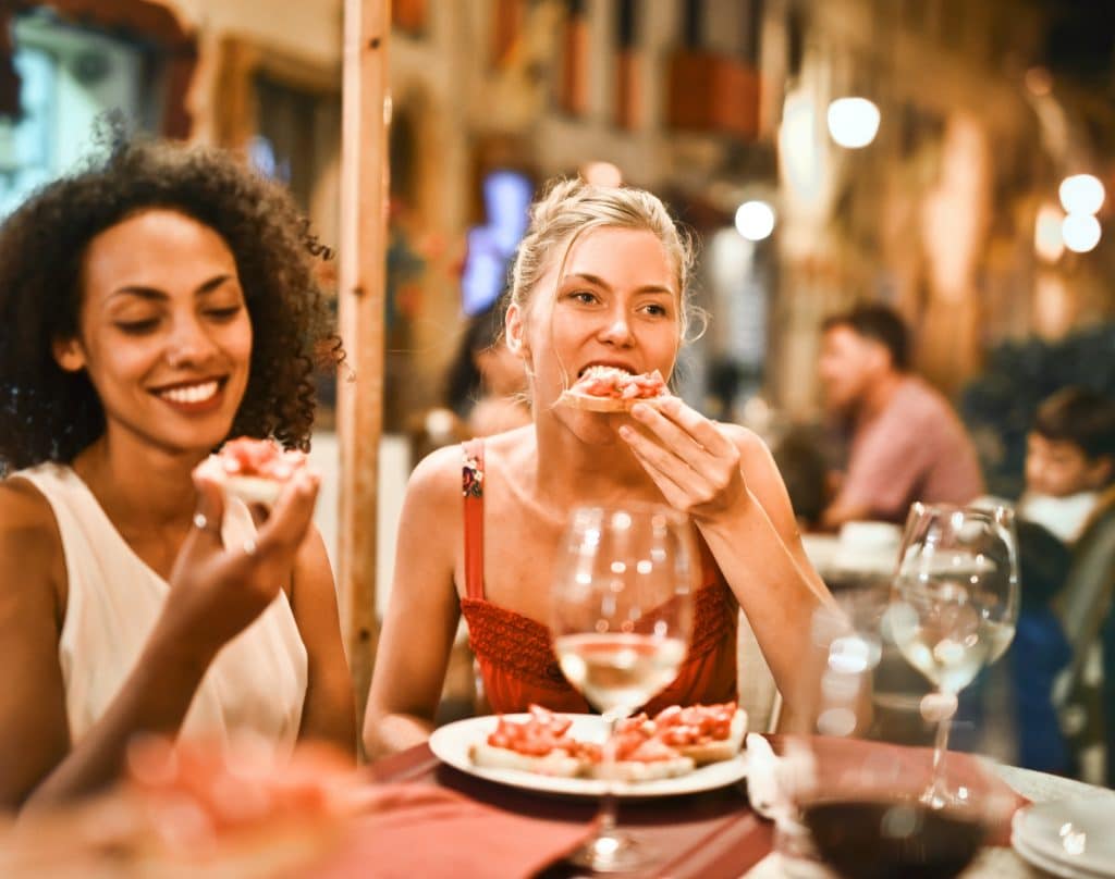 two women eating bruschetta