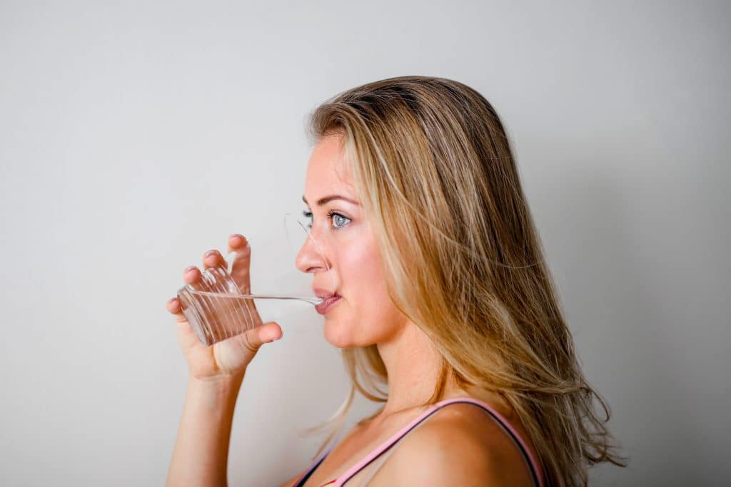 profile-of-a-blonde-woman-drinking-water-from-a-clear-cup