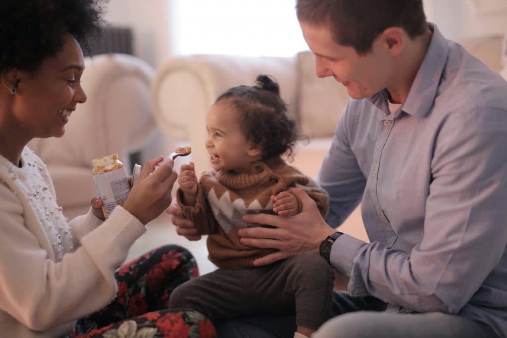 mother-and-father-holding-and-feeding-their-baby