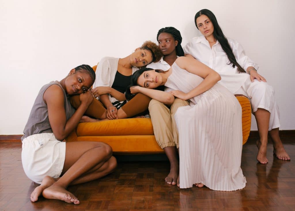 five-women-sitting-together-on-an-orange-couch