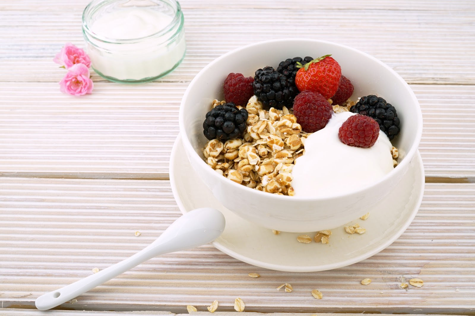 granola-and-yoghurt-with-strawberry-blueberries-and-raspberries-in-white-ceramic-bowl 