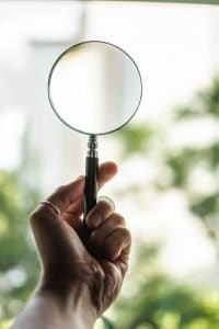 human-hand-holding-magnifying-glass