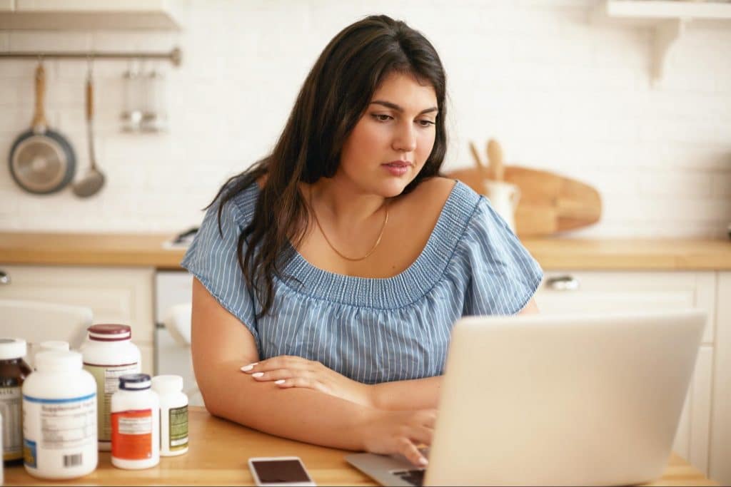 Woman checks the strains in probiotic supplement.