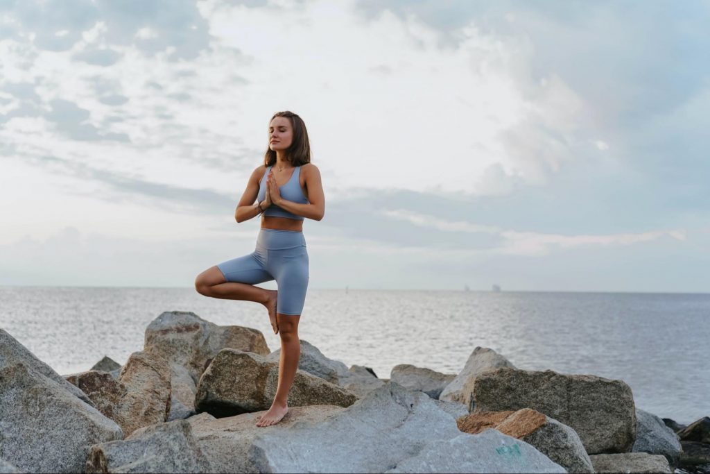 woman doing yoga outdoors on rock