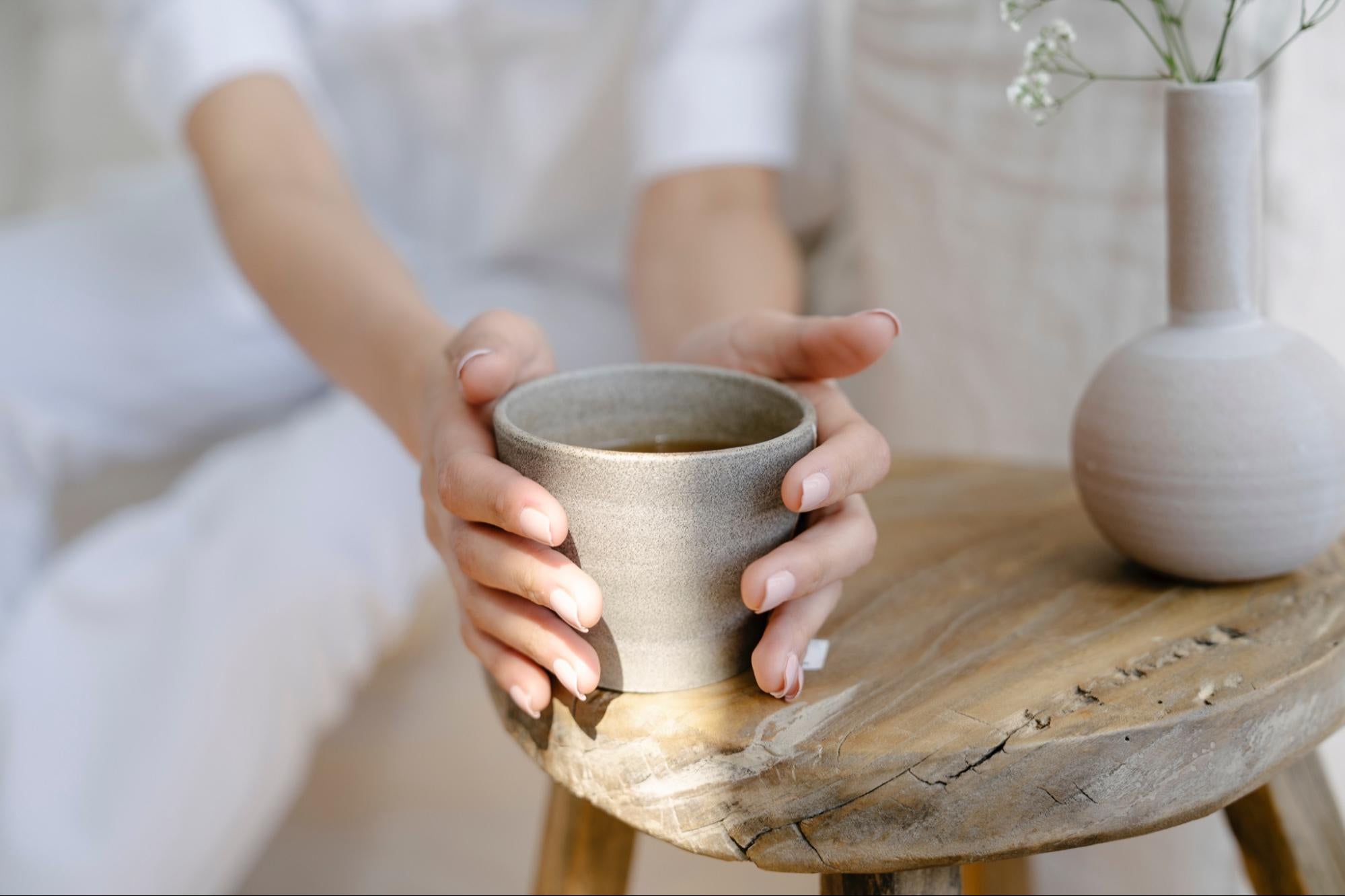 woman holding clay cup