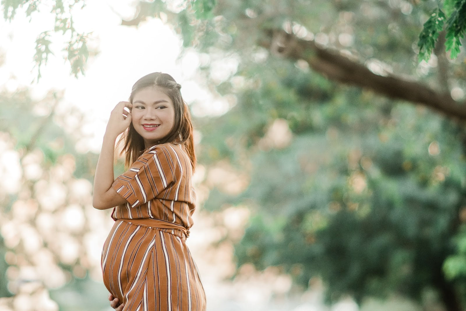 pregnant-woman-in-brown-dress-smiling