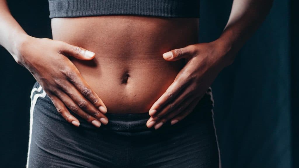 Woman with hands on belly.